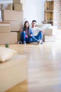 Genç Asya çift oturma üzerinde the zemin arasında yeni ev civarı araba