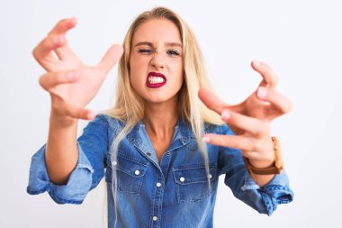 Genç, güzel bir kadın, sıradan bir kot gömlek giyiyor, izole edilmiş beyaz arka plan üzerinde duruyor öfkeden çıldırmış bir şekilde bağırıyor, elleri boğazlamaya çalışıyor, deli gibi bağırıyor.