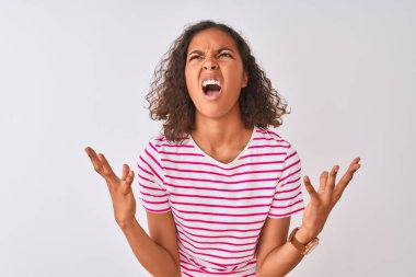 Pembe çizgili tişört giyen genç Brezilyalı kadın izole edilmiş beyaz arka planda çılgın deli bağırıyor ve agresif bir ifade ve kolla bağırıyor. Hayal kırıklığı konsepti.