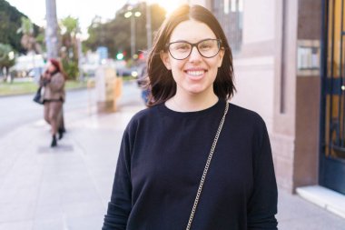 Güzel genç esmer kadın gülümsüyor heyecanlı yürürken 