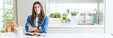 Geniş açılı bir bakış açısıyla güzel bir kadının suşi yerken şüpheli ve gergin bir şekilde kollarını kavuşturarak yüz ifadesini onaylamadığını gösteriyor. Negatif kişi.