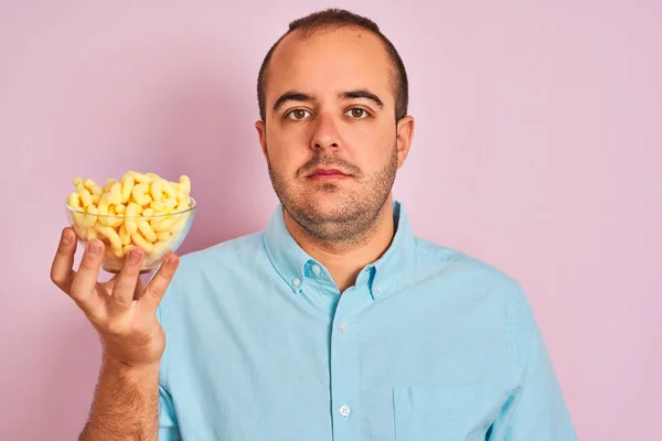 Jongeman Houden Kom Met Geëxtrudeerde Maïs Staan Geïsoleerde Roze Achtergrond — Stockfoto