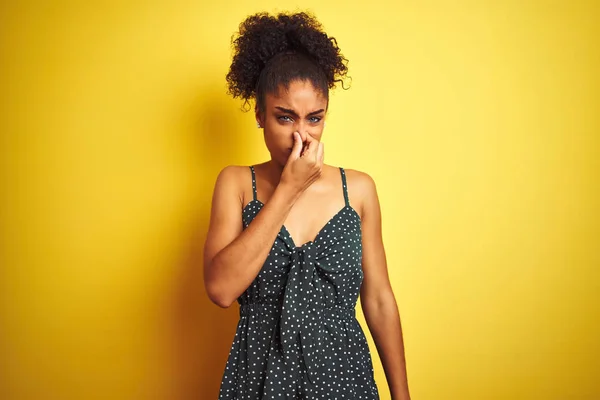 穿着夏令休闲服的非洲裔美国女人在孤立的黄色背景上闻到一股难闻难闻的气味 用手指捂住鼻子屏住呼吸 臭味概念 — 图库照片