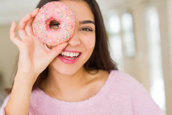 Hermosa joven sonriendo mirando a través de rosado donut en el —  Fotos de Stock