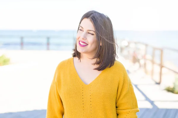 Beautiful young woman smiling cheerful walking by the sea on pro — Stock Photo, Image