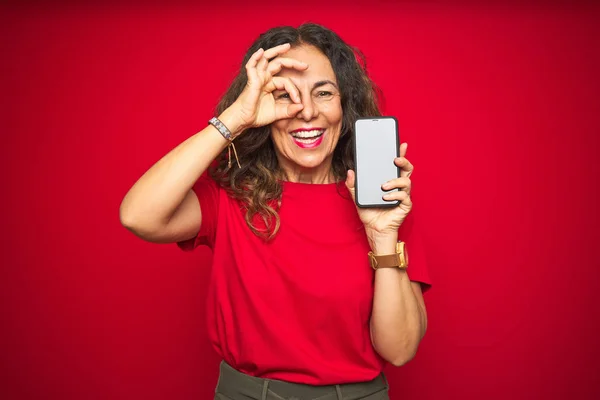 Seniorin Mittleren Alters Zeigt Bildschirm Des Smartphones Über Rotem Isoliertem — Stockfoto