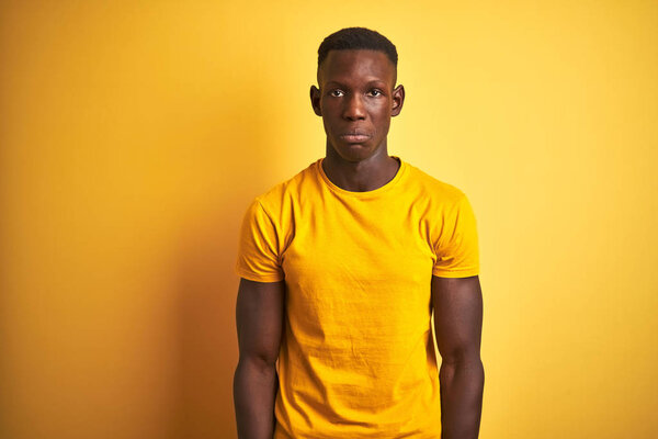 Young african american man wearing casual t-shirt standing over isolated yellow background depressed and worry for distress, crying angry and afraid. Sad expression.