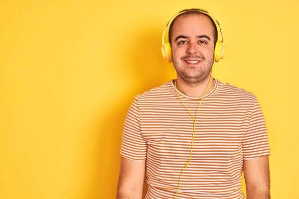 Joven Escuchando Música Usando Auriculares Parados Sobre Fondo Amarillo Aislado —  Fotos de Stock