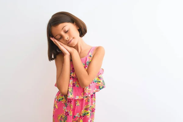 年轻美丽的小女孩穿着粉红色的花裙子 站在孤独的白色背景上 睡懒觉 双手合十 闭着眼睛微笑 — 图库照片