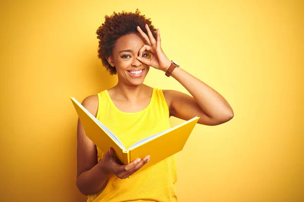 Afroamerikansk Kvinna Läser Bok Över Gul Isolerad Bakgrund Med Glad — Stockfoto