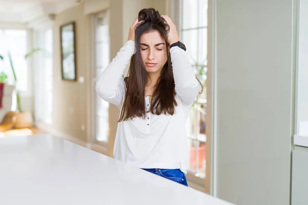 Schöne Junge Frau Sitzt Auf Weißem Tisch Hause Unter Kopfschmerzen — Stockfoto