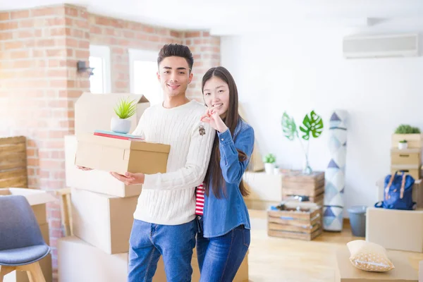 Junges asiatisches Paar hält Schlüssel für neues Haus, lächelt glücklich und — Stockfoto