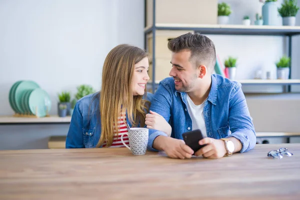 Mladý párek relaxace s šálkem kávy a použitím smartph — Stock fotografie