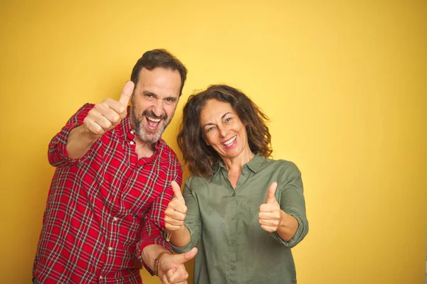 Belo Casal Meia Idade Sobre Fundo Amarelo Isolado Aprovando Fazer — Fotografia de Stock