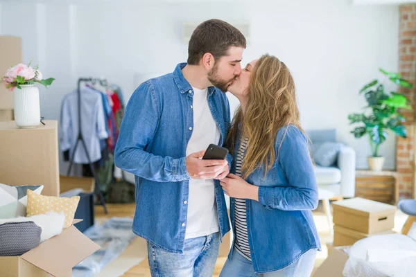 Junges Paar zieht mit Smartphone in ein neues Haus — Stockfoto