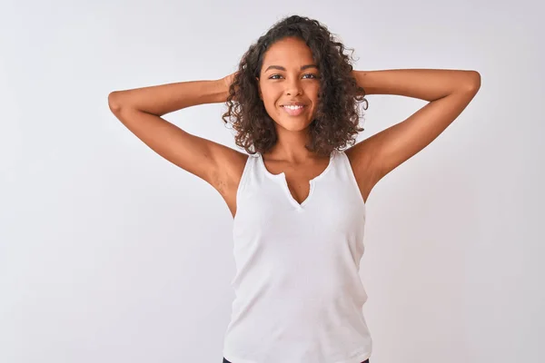 孤立した白い背景の上に立つカジュアルTシャツを着た若いブラジル人女性リラックスしてストレッチ 腕と手頭と首の後ろに笑顔幸せ — ストック写真