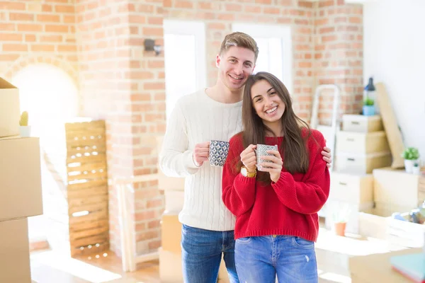 Belo jovem casal sorrindo no amor bebendo uma xícara de café — Fotografia de Stock