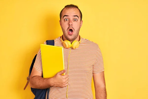 Estudiante Con Auriculares Mochila Sosteniendo Cuaderno Sobre Fondo Amarillo Aislado —  Fotos de Stock