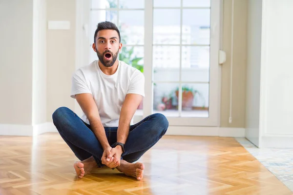 Knappe Spaanse Man Met Casual Shirt Vloer Thuis Bang Geschokt — Stockfoto