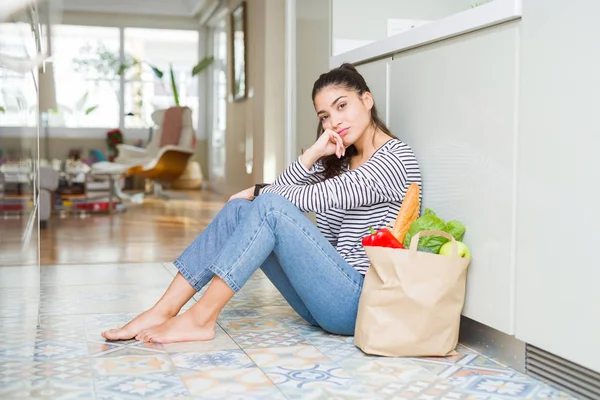 Jovem Mulher Sentada Chão Cozinha Com Saco Papel Cheio Mantimentos — Fotografia de Stock