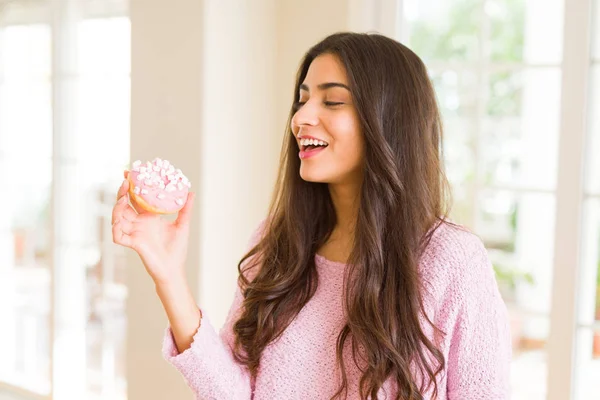 ピンクのおいしいドーナツを食べる若い美しい女性の笑顔 — ストック写真