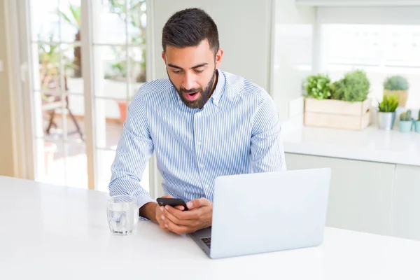 Laptop Akıllı Telefon Kullanan Yakışıklı Spanyol Adamı Şaşırmış Bir Yüzle — Stok fotoğraf