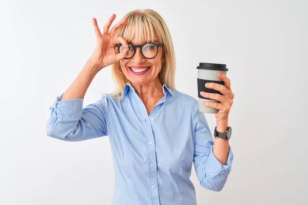 Middle age businesswoman wearing glasses drinking coffee over isolated white background with happy face smiling doing ok sign with hand on eye looking through fingers