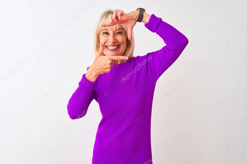 Middle age woman wearing purple t-shirt standing over isolated white background smiling making frame with hands and fingers with happy face. Creativity and photography concept.
