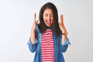 İzole edilmiş beyaz arka plan üzerine çizgili t-shirt ve kot gömlek giyen genç Çinli kadın kollarını kaldırmış ve gözlerini kapatmış heyecanla haykırarak başarıyı kutluyor. Kazanan konsept