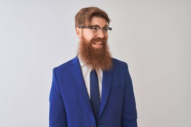 Genç Redhead İrlandalı işadamı elbise ve gözlük üzerinde izole beyaz arka plan üzerinde yüz, doğal ifade gülümseme ile kenara bakıyor giyiyor. Güven gülüyor.