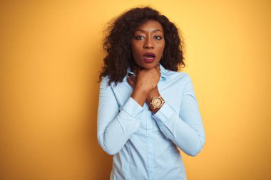 Afrikalı Amerikalı iş kadını sarı arka planda zarif bir gömlek giyip bağırıyor ve boğuluyor çünkü acı verici bir boğulma var. Sağlık problemi. Boğulma ve intihar konsepti.