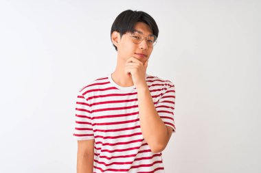 Gözlüklü ve çizgili tişörtlü genç Çinli adam izole edilmiş beyaz arka planda duruyor. Kameraya bakıyor ve kollarını kavuşturup çenesine kaldırarak gülümsüyor. Olumlu düşünüyorum..