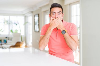 Evde rahat t-shirt giyen İspanyol yakışıklı kapsayan ağız elle hata için şok. Gizli kavramı.