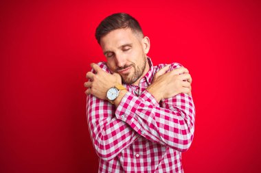 Kızıl ötesi yakışıklı bir adam kendine sarılıyor mutlu ve pozitif, kendinden emin gülümsüyor. Sevgi ve özgüven.