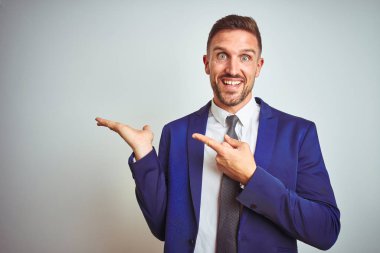 Beyaz tenli, yakışıklı iş adamı kameraya hayret ediyor ve gülümsüyor..