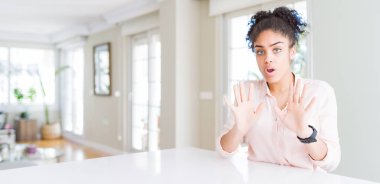 Afro saçlı güzel Afro-Amerikan kadını geniş açılı. Avuçlarını kaldırıyor, reddediyor ve iğrenç bir ifadeyle reddediyor. Dur ve yasakla.