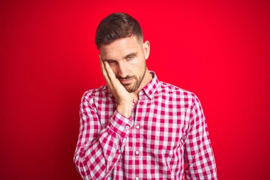 Genç ve yakışıklı bir adam soyutlanmış arka planda yaşıyor. Kollarını kavuşturarak depresyondan sıkılmış ve yorgun görünüyor..