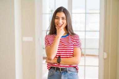 Emin çapraz kollar ve çeneme kaldırdı el ile gülümseme ile kameraya bakarak rahat t-shirt giyen genç güzel kadın. Pozitif düşünce.