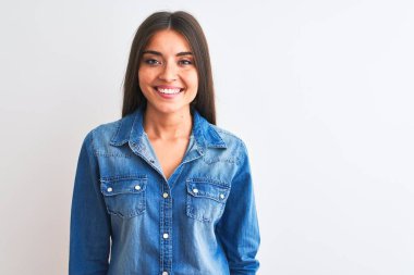 İzole edilmiş beyaz arka planda duran, mutlu ve havalı bir gülümsemesi olan sıradan bir kot gömlek giyen genç ve güzel bir kadın. Şanslı kişi..