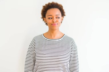 Beyaz arka planda çizgili süveter giyen, gülümseyen ve başka yöne bakan güzel Afrikalı Amerikalı kadın..