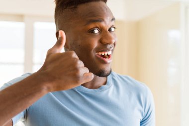 Yakışıklı African genç adam yapıyor thumbs yukarı jest, büyük symbol