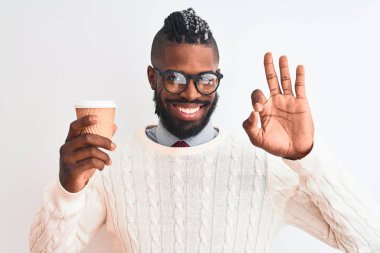 Örgü örüp kahve içen Afrikalı Amerikalı adam izole edilmiş beyaz arka planda kahve içiyor. Tamam işareti yapıyor, mükemmel bir sembol.
