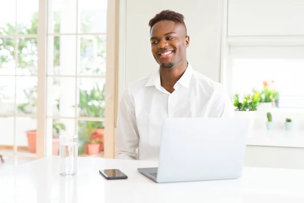 アフリカ系アメリカ人のビジネスマンの顔に笑みを浮かべて横に離れて見てラップトップを使用して作業し 自然な表情 自信を持って — ストック写真