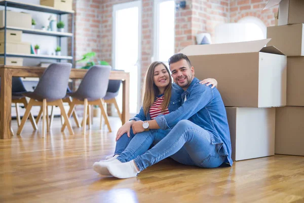 Young beautiful couple in love moving to new home, sitting on th — Stock Photo, Image