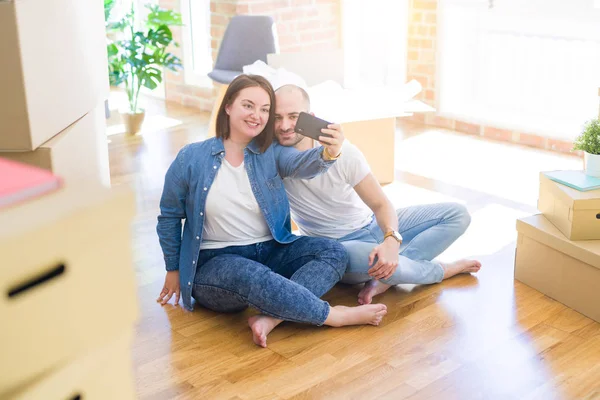 Yeni evde Smartphone kullanarak bir resim fotoğraf çekerken genç çift — Stok fotoğraf