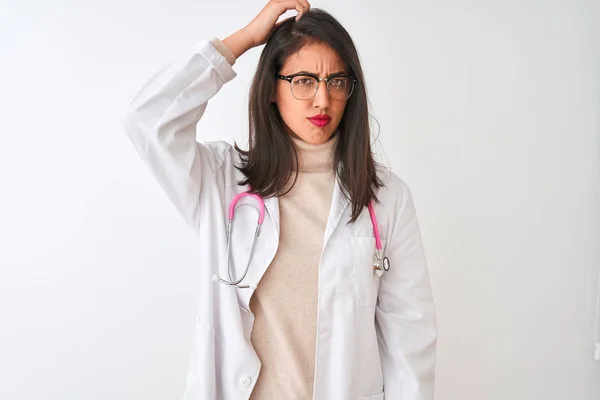 Chinese doctor woman wearing coat and pink stethoscope over isolated white background confuse and wonder about question. Uncertain with doubt, thinking with hand on head. Pensive concept.