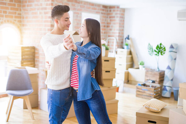 Young asian couple dancing and smiling celebrating moving to a n