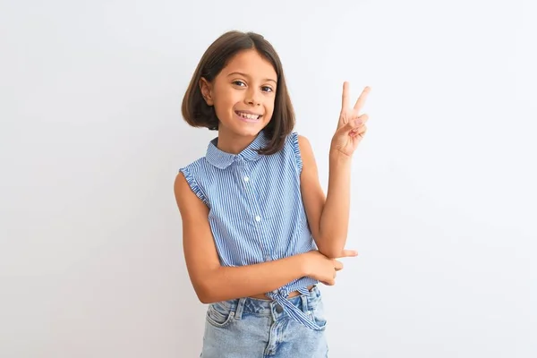 青いカジュアルなシャツを着た若い美少女が 白い背景の上に立ち カメラが勝利サインをするのを見て微笑む 第二番 — ストック写真