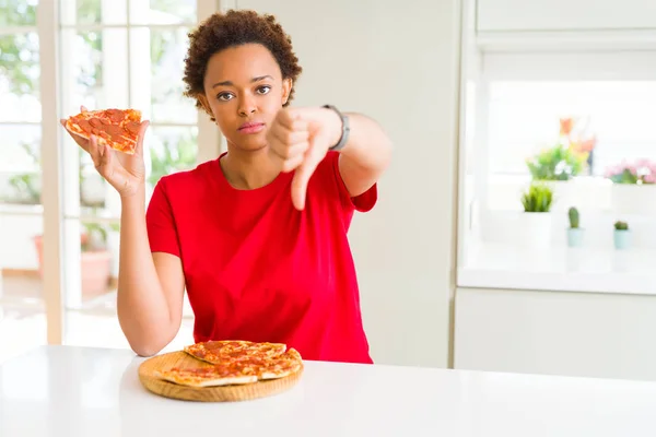 若いアフリカ系アメリカ人女性おいしいPeperoniピザを食べて怒っている顔 親指ダウンで嫌いを示す負の記号 拒絶概念 — ストック写真