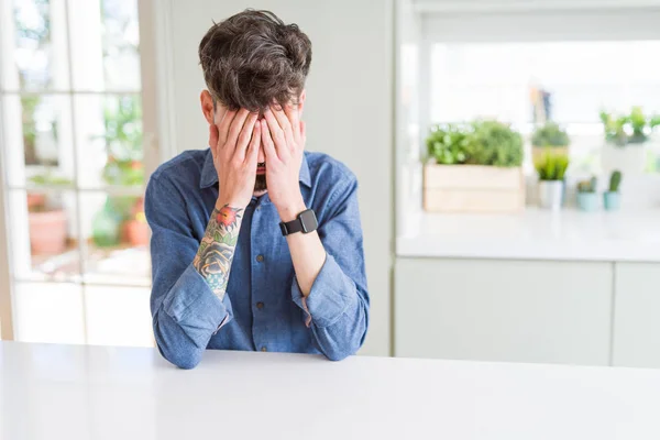 Jovem Vestindo Camisa Casual Sentado Mesa Branca Com Expressão Triste — Fotografia de Stock